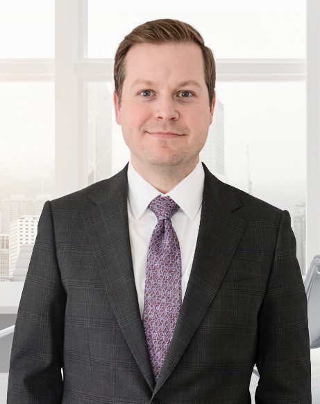 Professional man in a suit standing in a bright office.